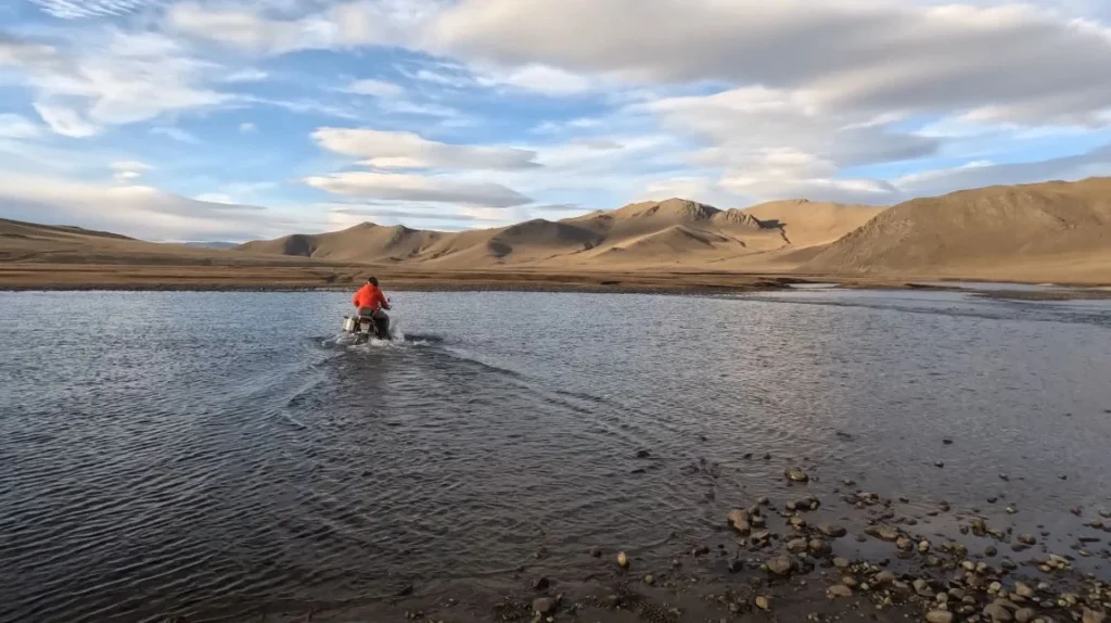 someone crossing water on motorcycle