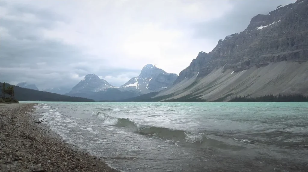Bow Lake shoreline with the characteristic turquoise color and mountain backdrop