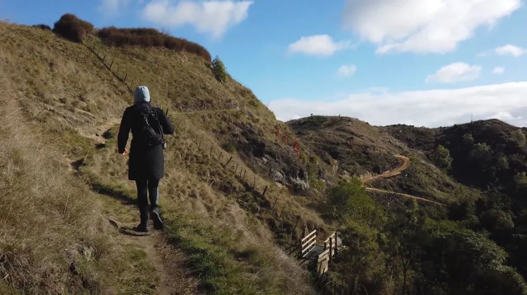 Hiking trail through rolling green hills.