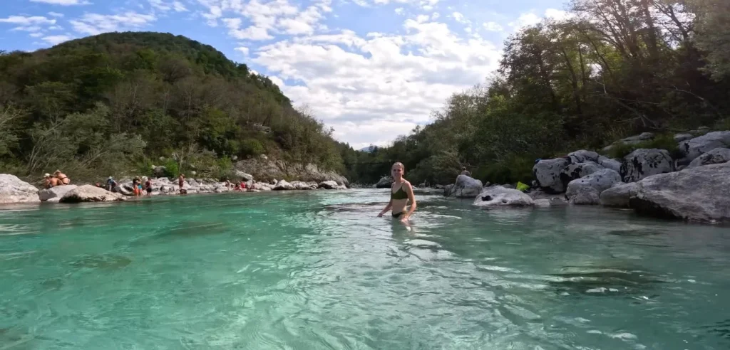 Woman wading in Soča, turquoise water